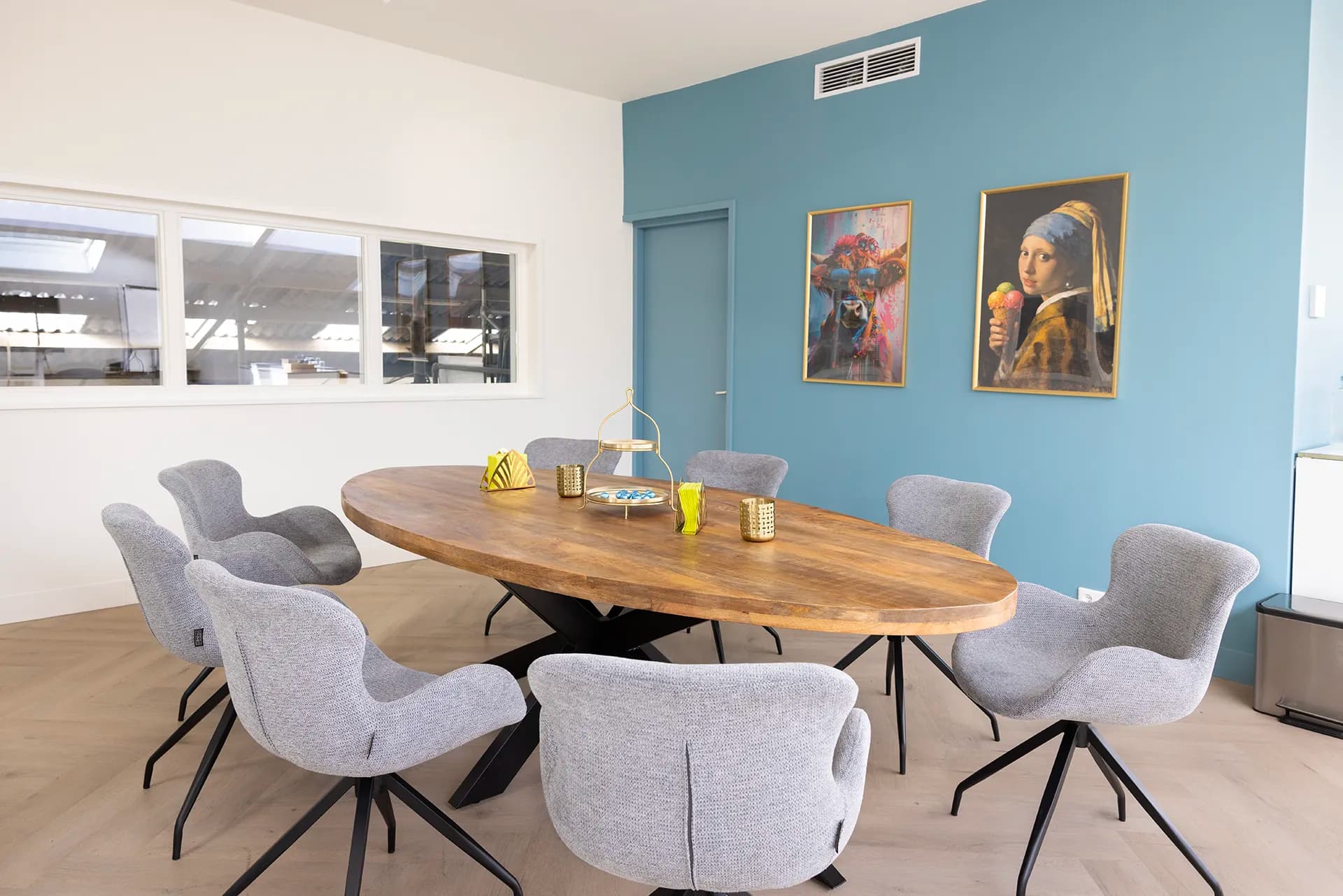 The boardroom with the oval table, including Girl with a Pearl Earring holding an ice cream